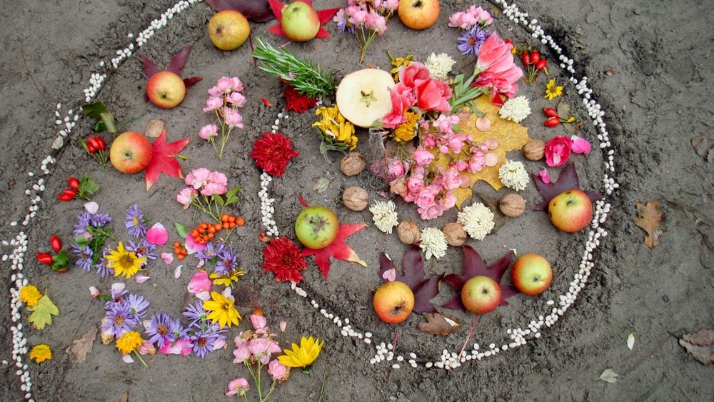 a Litha altar featuring fresh flowers, fruit, and nuts