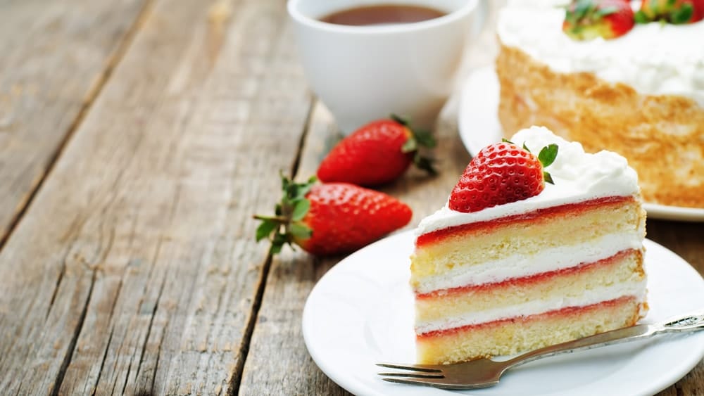 a delicious strawberry cake with a cup of tea and some fresh picked strawberries