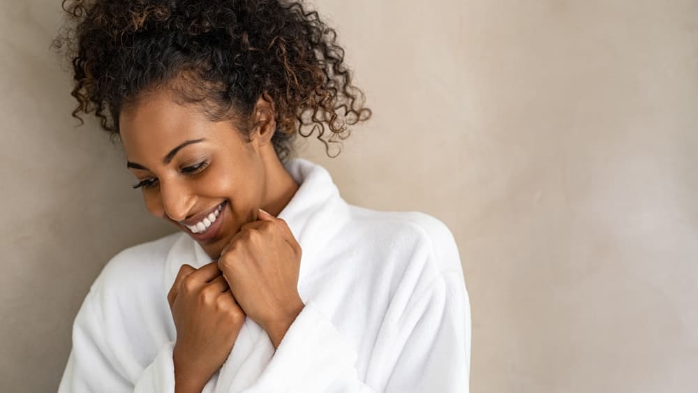A smiling woman wearing a robe