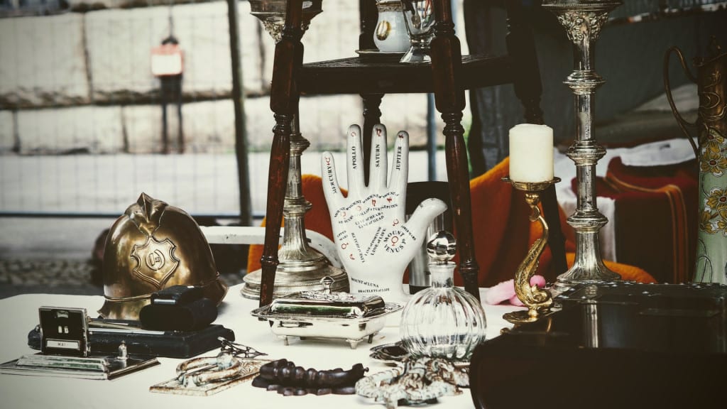 An antique palm reading guide surrounded by other antiques