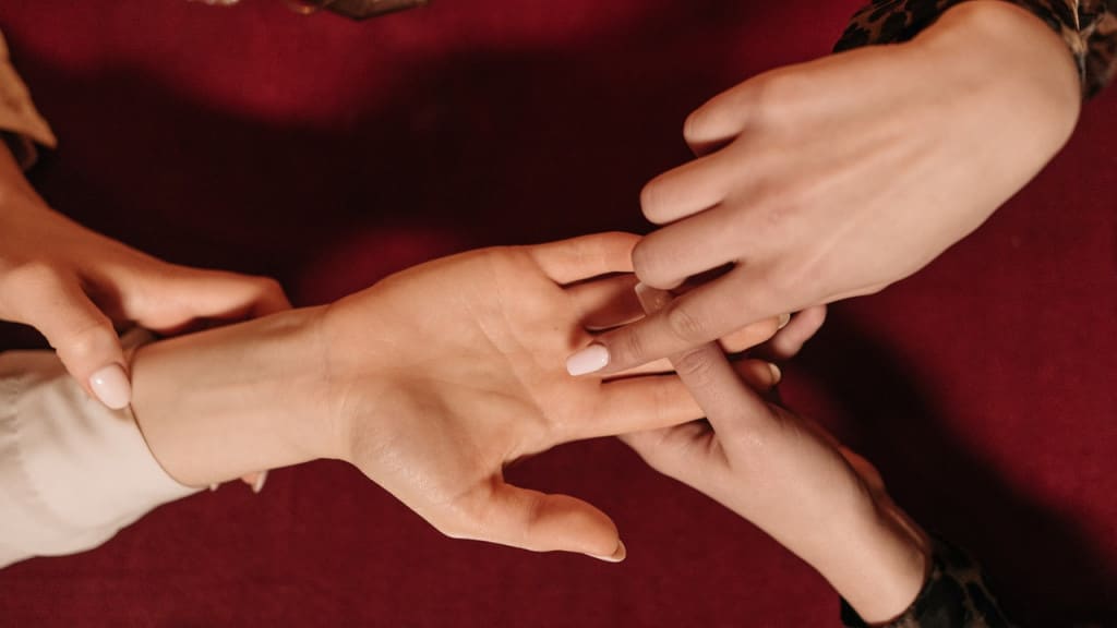 An overhead view of a woman reading another woman's palm