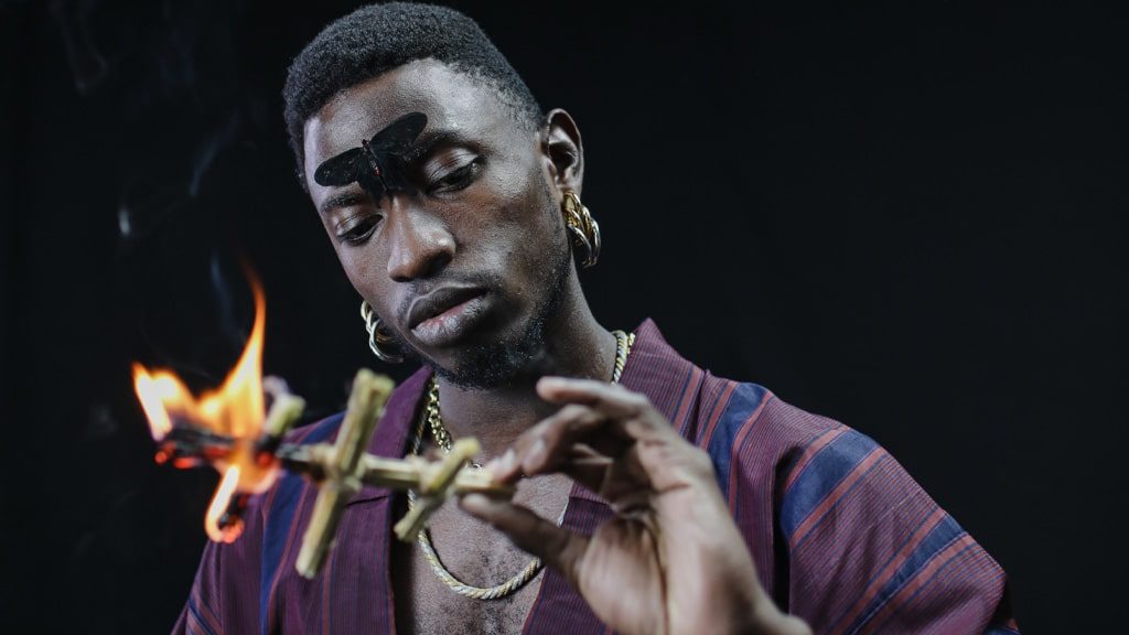 A male witch burning a smudge stick