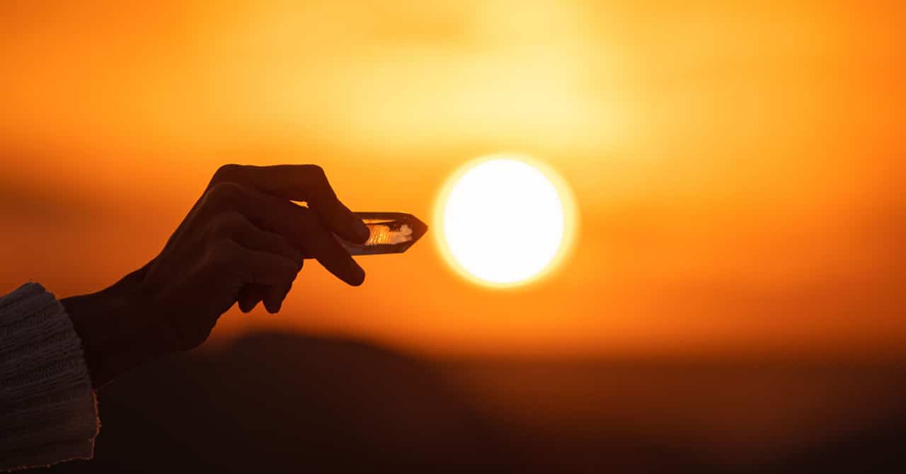 A Person Holding Crystals with a Sunset Background