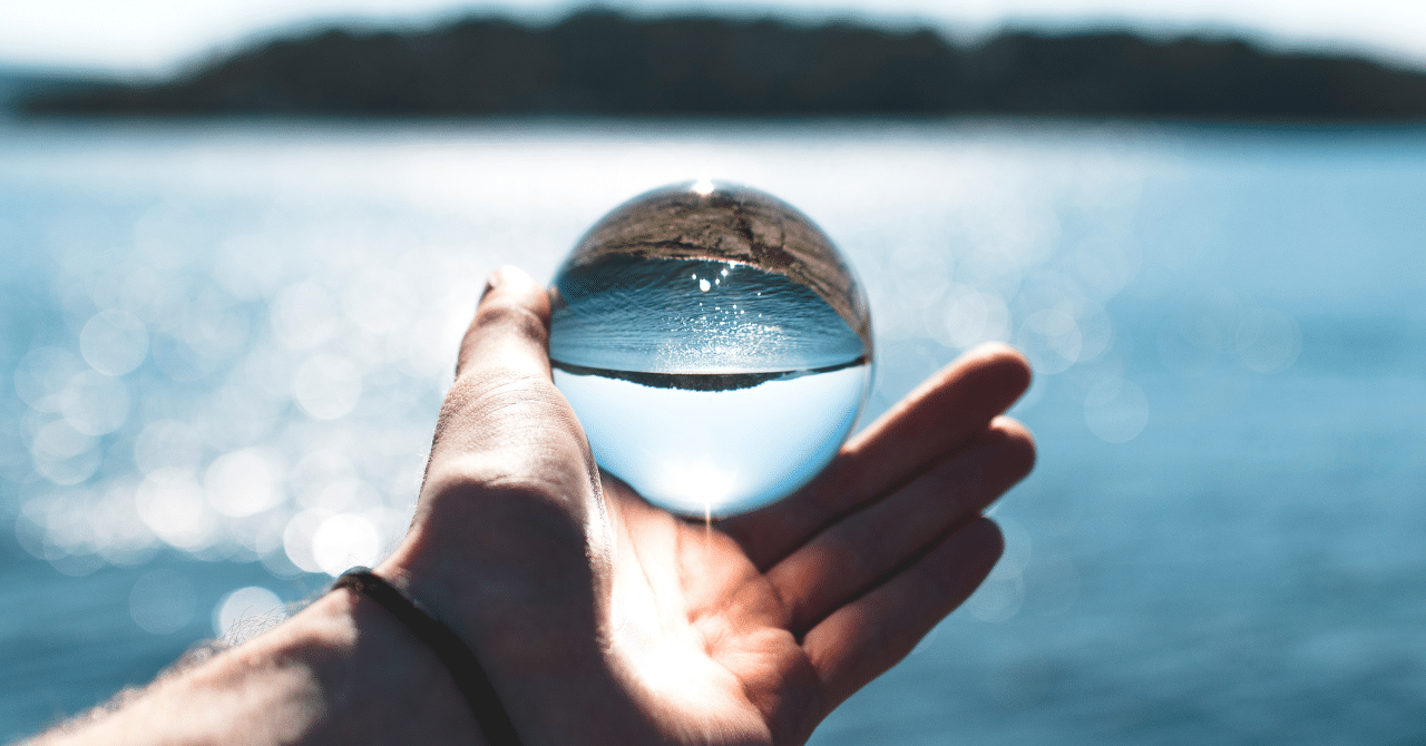 A Person Holding Crystal with a Water Background