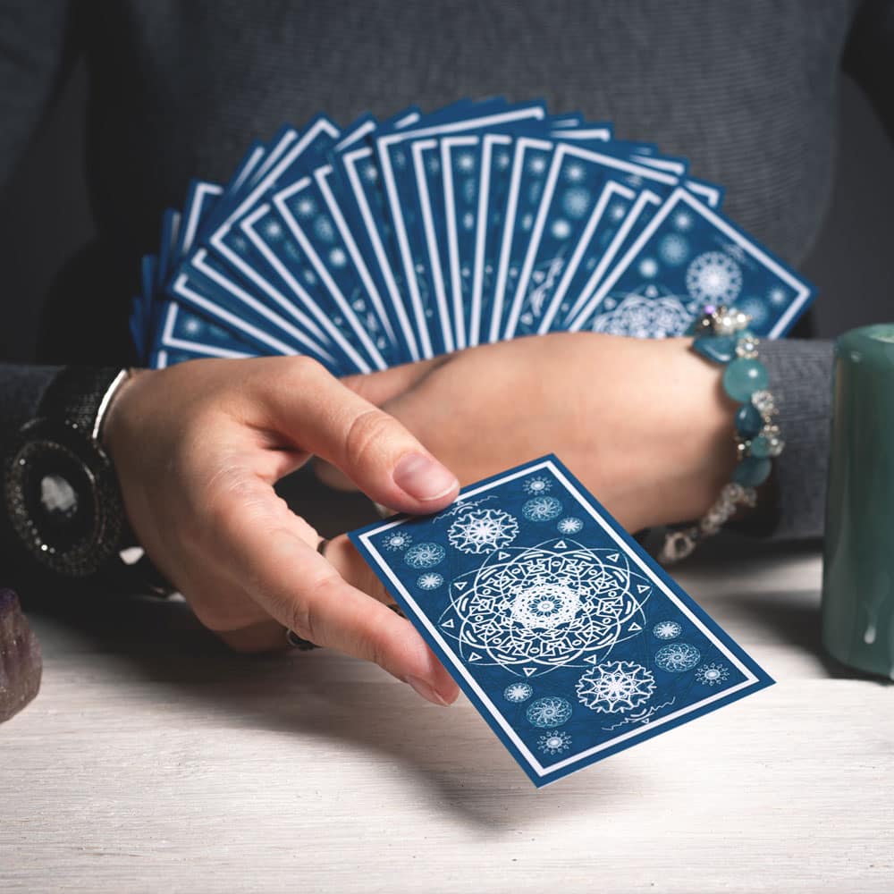 A woman with a deck of blue tarot cards