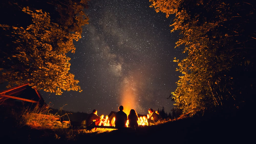 group of wiccans gathered around a Beltane holiday bonfire