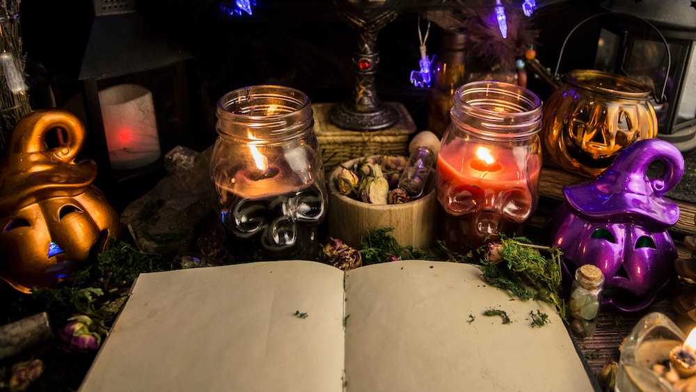 A book of shadows surrounded by a Fall themed scene