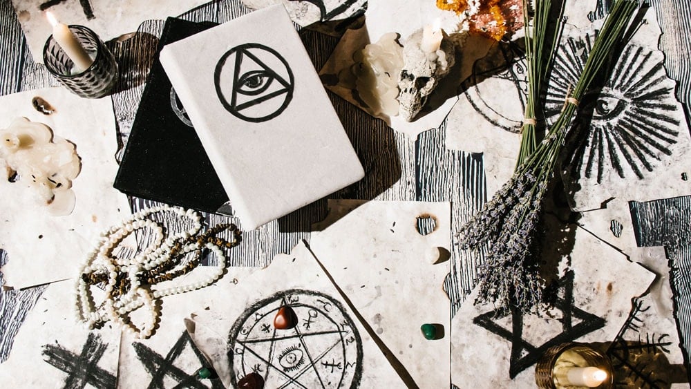 Drawings of different sigils on paper and books