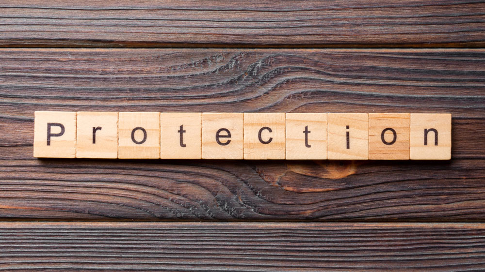 Wooden tiles spelling out protection over a wooden deck