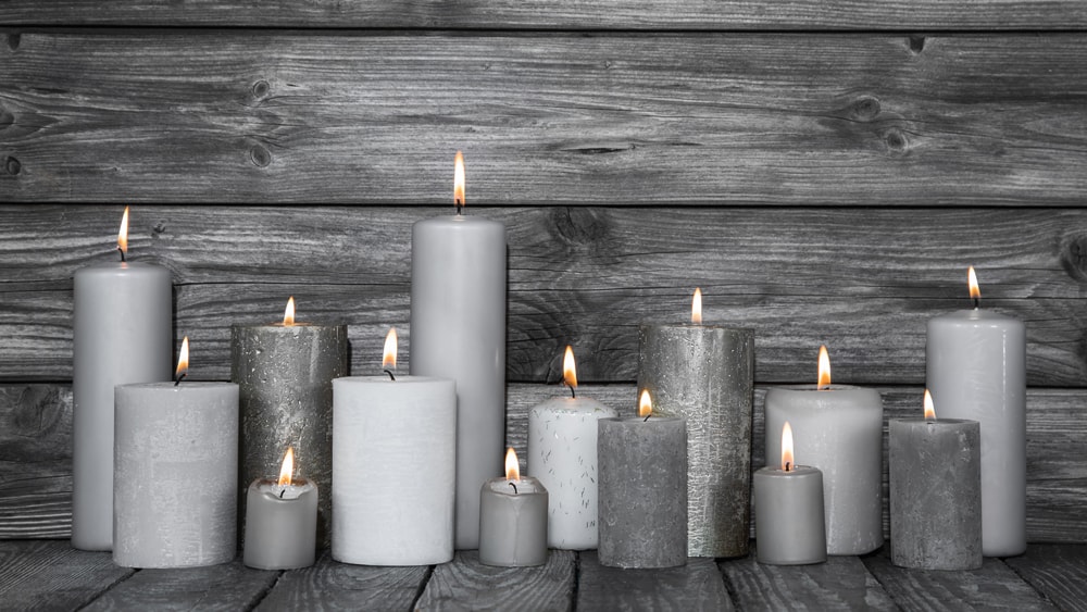 Gray candles on a wooden floor with a wooden background