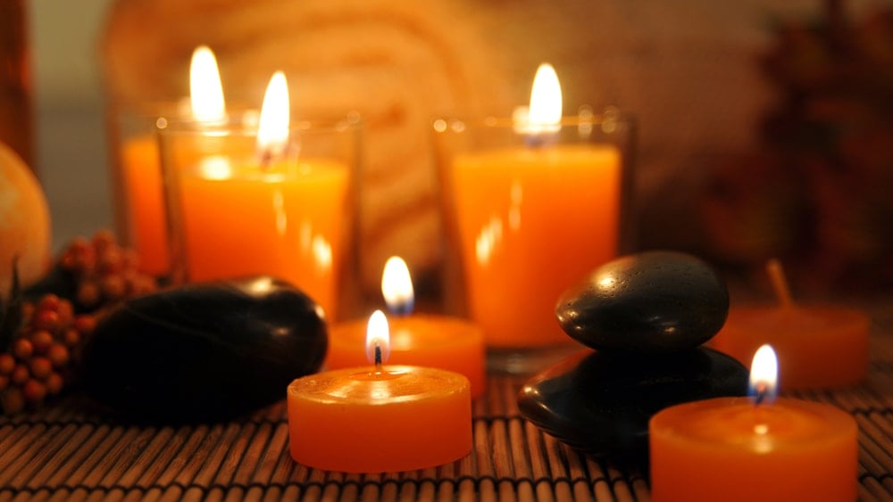 Orange candles and black stones on a mat