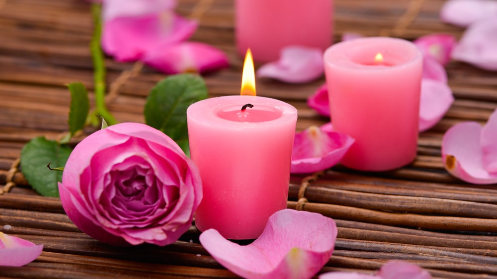 Pink candles and pink roses on a twig mat