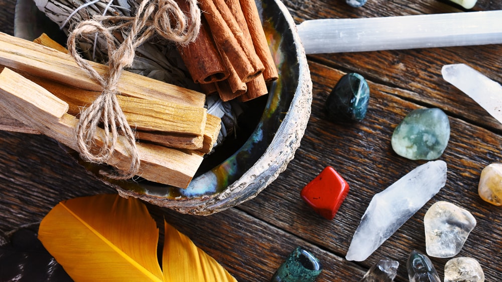 An assortment of magickal materials: wood, cinnamon, and crystals