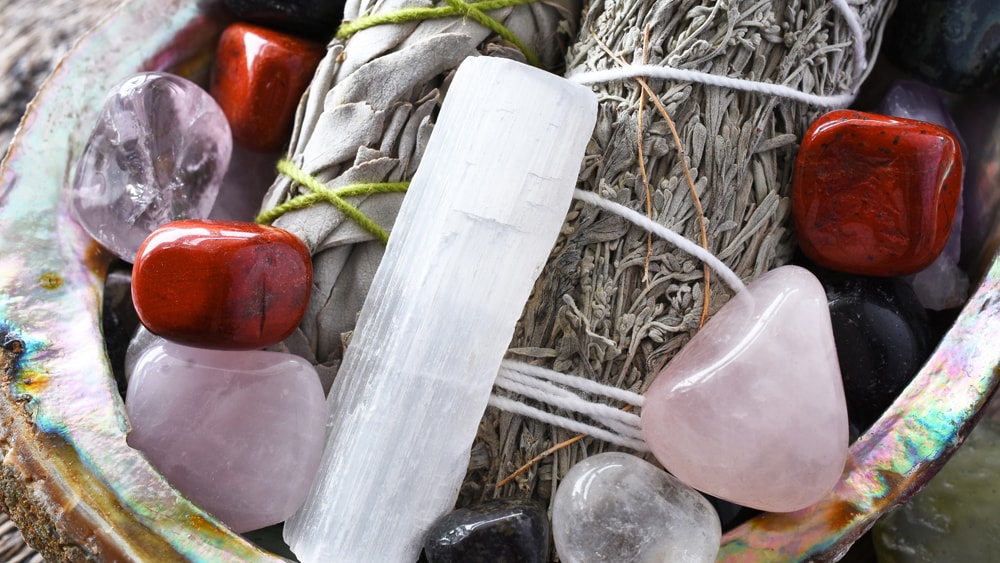 Various quartz crystals and dried herbs in a geode bowl