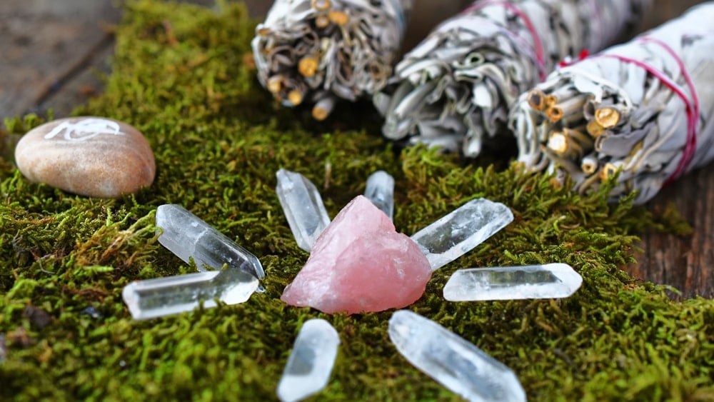 Quartz crystals and bunches of sage on a bed of moss