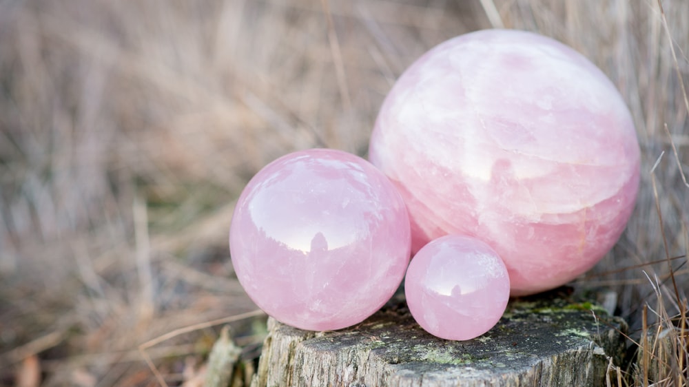 Three different sized rose quartz spheres