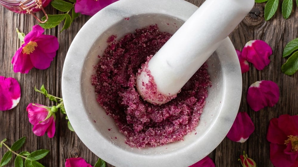 Rose petals being crushed in a mortar and pestle