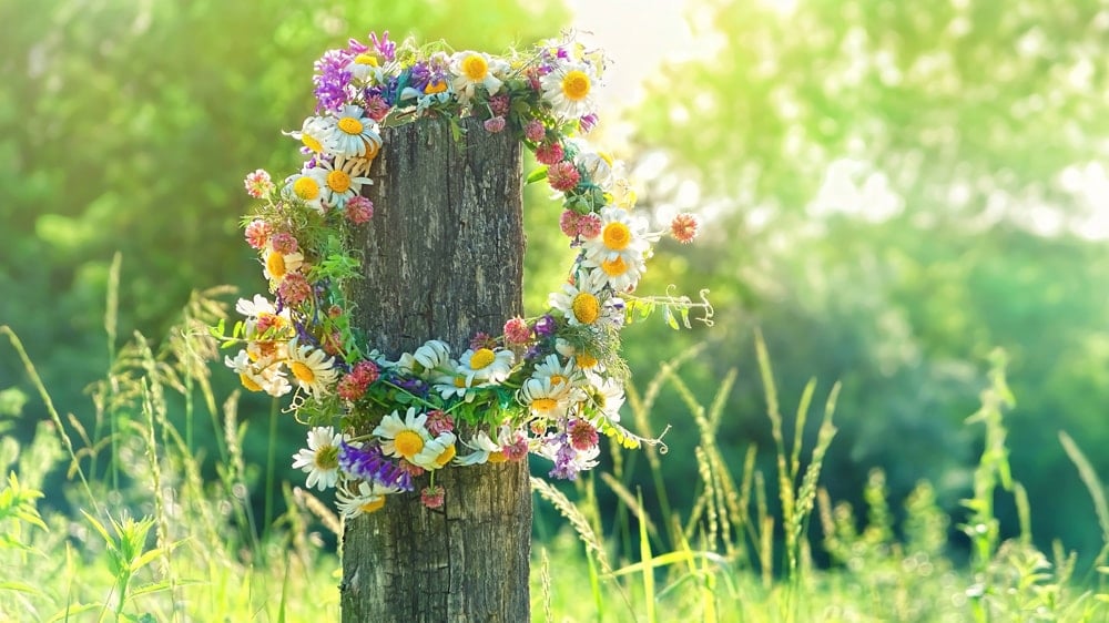 a flower crown hanging on a post in the summer