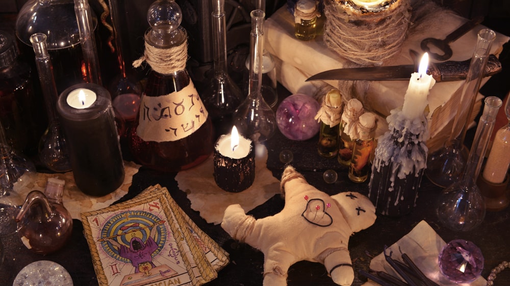 A Hoodoo altar featuring tarot cards, a doll, a skeleton key, and more