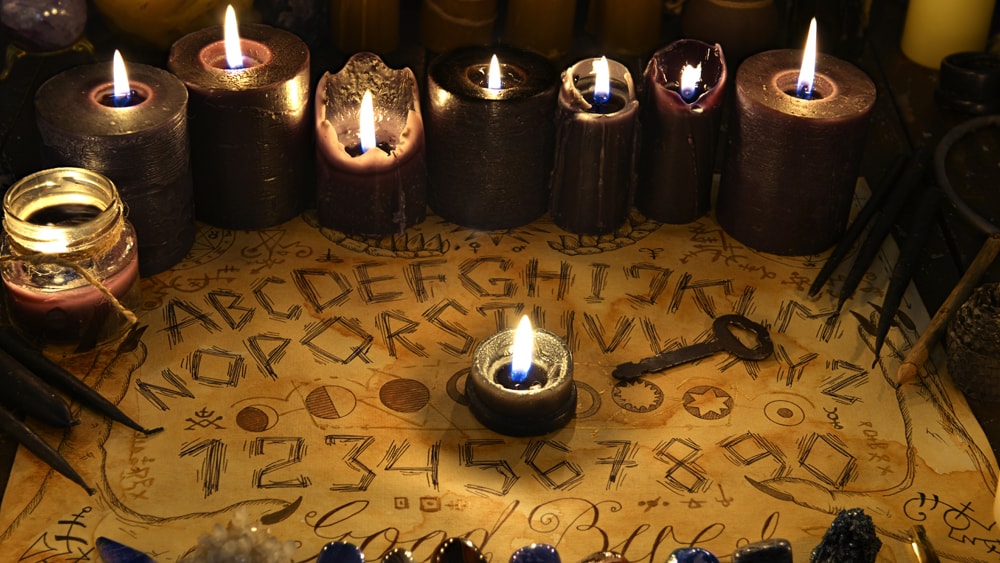 Purple Candles behind a Ouija board