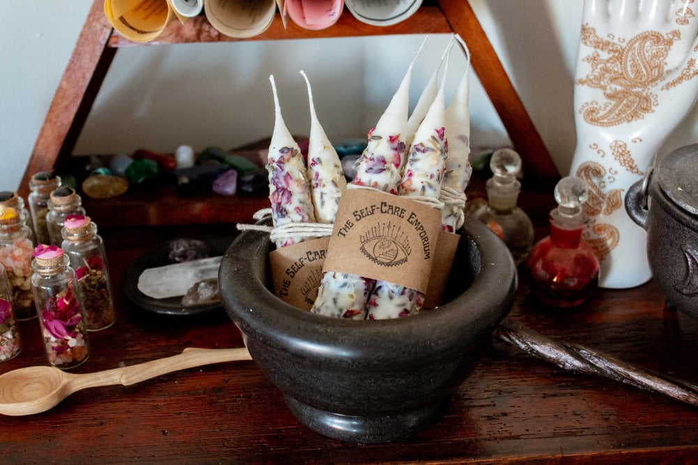 an altar with jars of spell ingredients and hand dipped candles