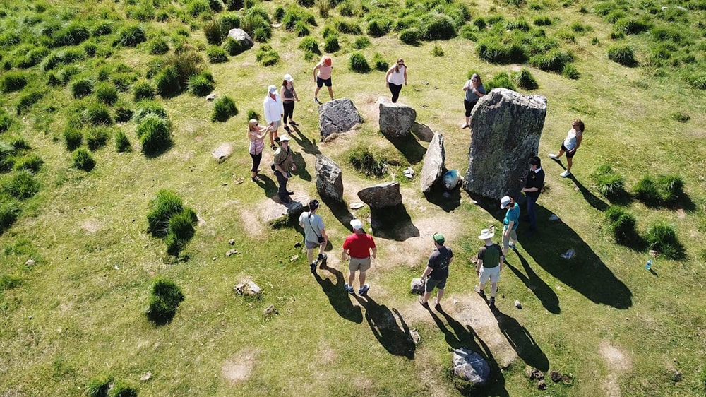 A group tour viewing an ancient Lughnasadh ritual site