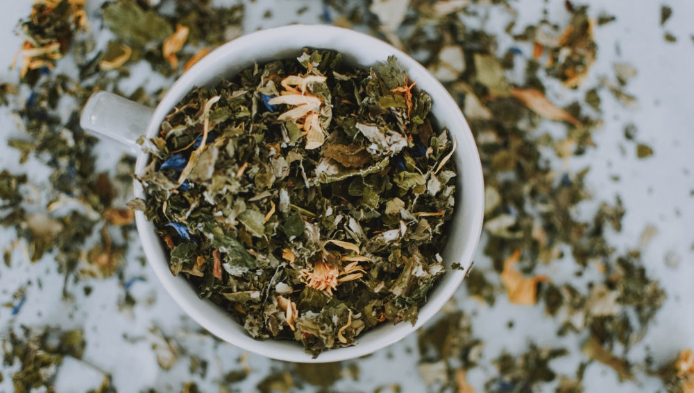 A mug filled with a variety of dried herbs