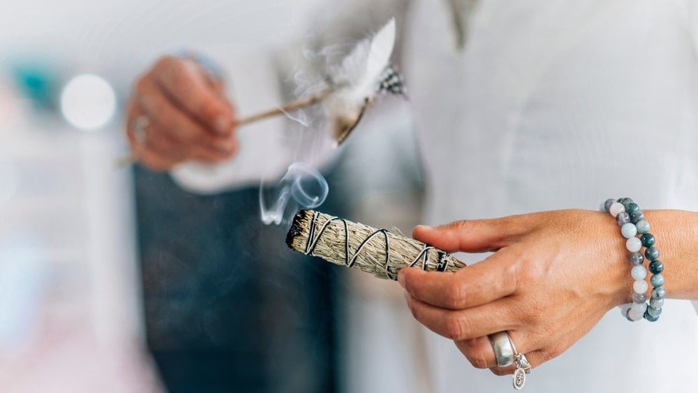 a person smudging themselves with sage