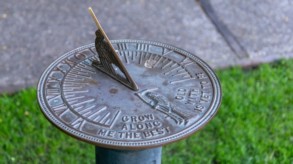 A metal sundial on a lawn