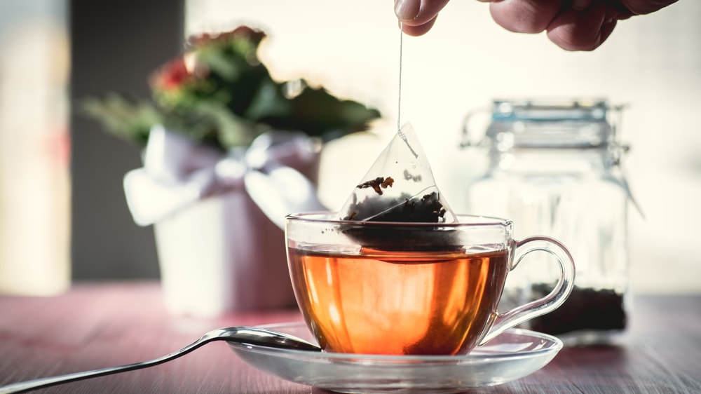 A tea bag dipping into a cup of tea