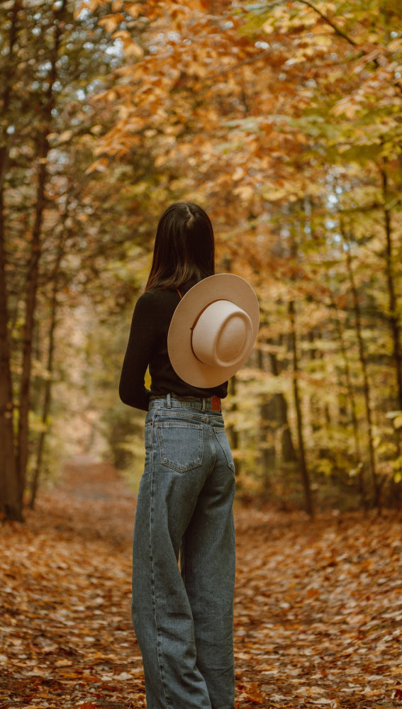 A woman walking through a forest in autumn