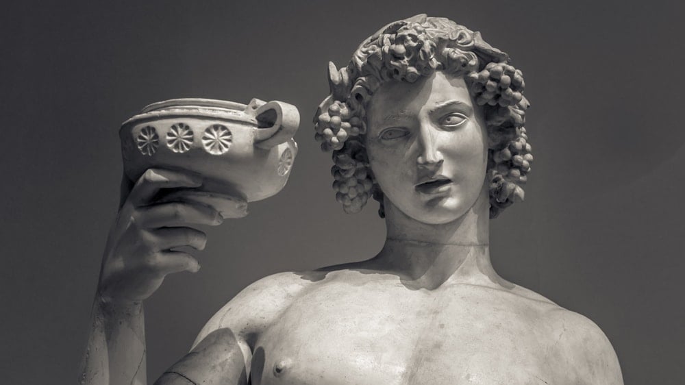 A statue of the Greek god Dionysus holding a chalice of wine