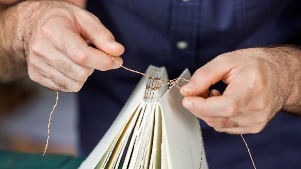 A man binding a book by hand