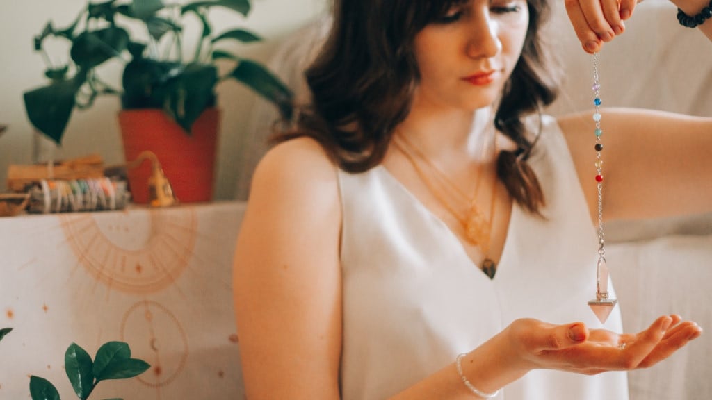 A woman holding a crystal pendulum