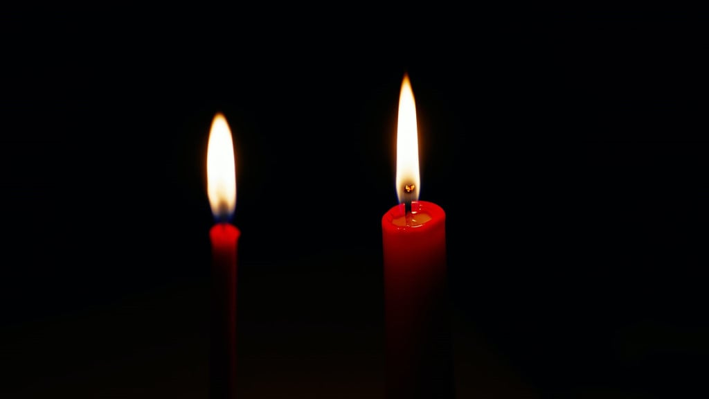two red candles burning in the darkness