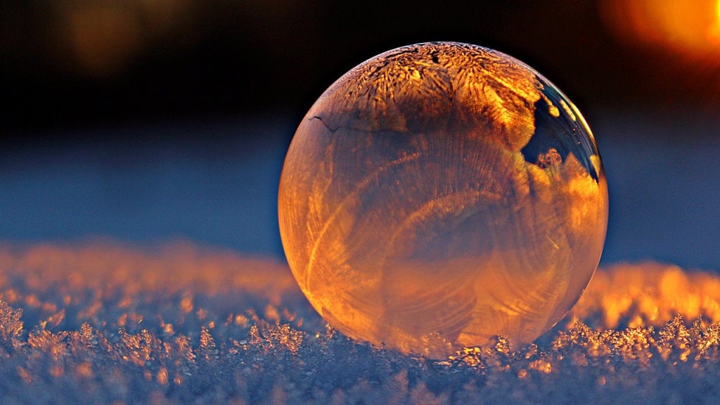 A frozen glass sphere being hit by the light of the sunrise