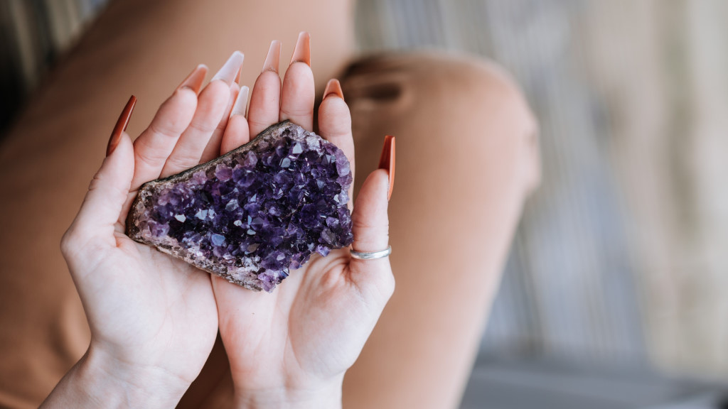 a woman holding an amethyst crystal