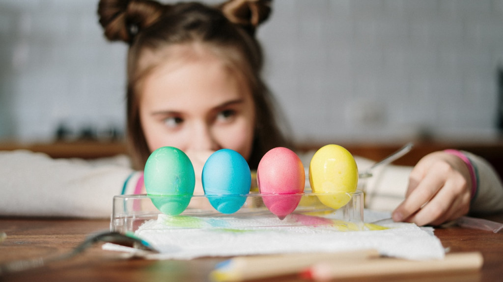 A girl with eggs dyed in a springtime color palette