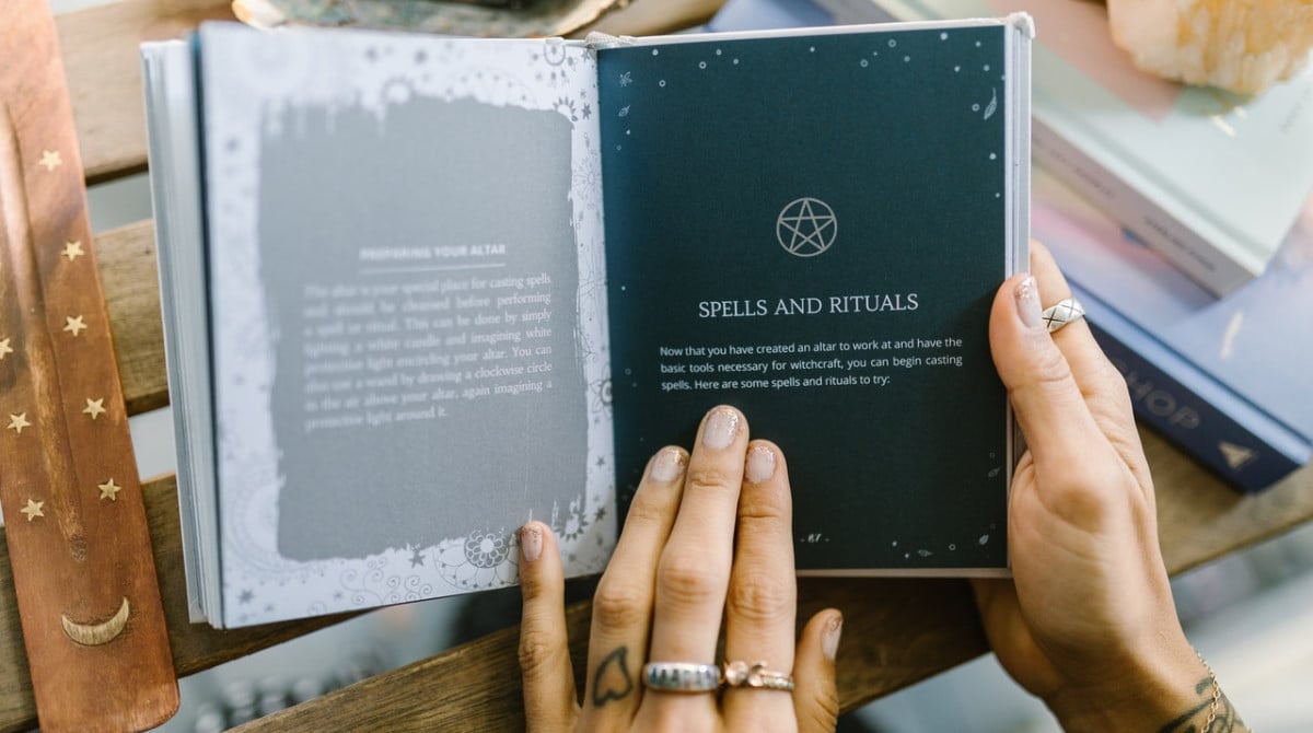 A woman holding a book about Wicca