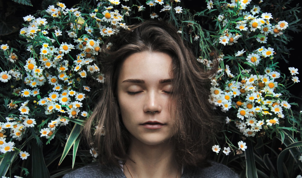 A woman in a deep sleep surrounded by chamomile flowers