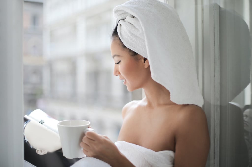 A woman having a cup of tea in the morning while reading a book