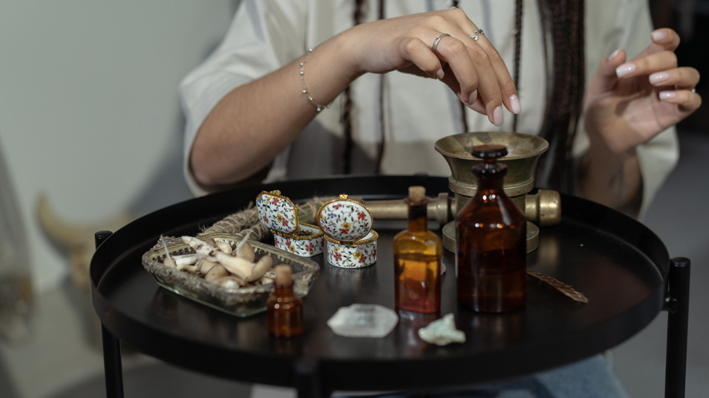 A witch mixes herbs in a mortar for a ritual