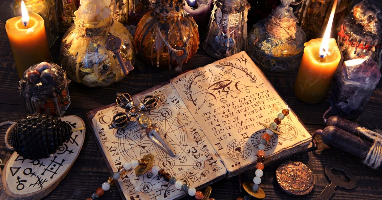 An old book with sigils and candles on the table