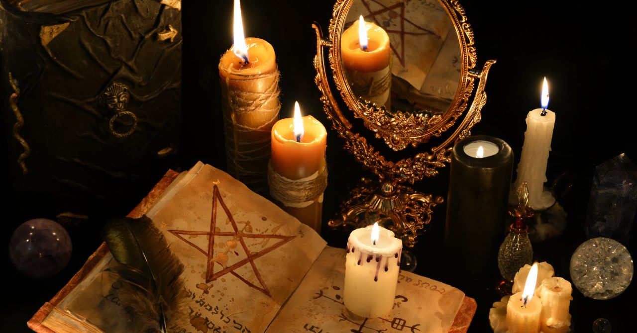 witch book, candels and mirror on the table